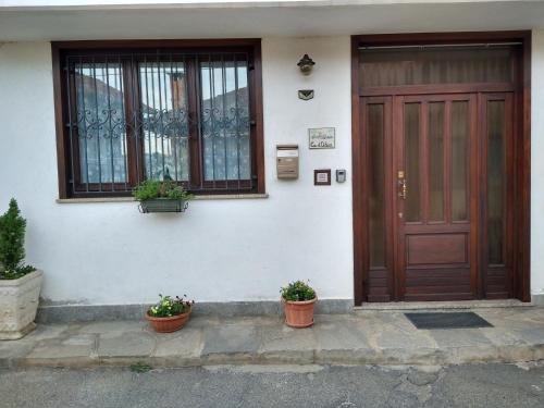 Ein Haus mit zwei Topfpflanzen vor der Tür in der Unterkunft CA d'ADUA in Pray