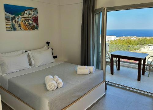 a bedroom with a bed and a balcony with a table at Lovely Hot-L in Fira
