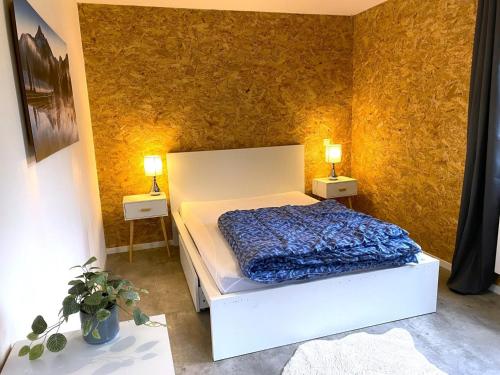 a bedroom with a bed and two lamps on two tables at Chez mathilde et sÉbastien in Rubigny