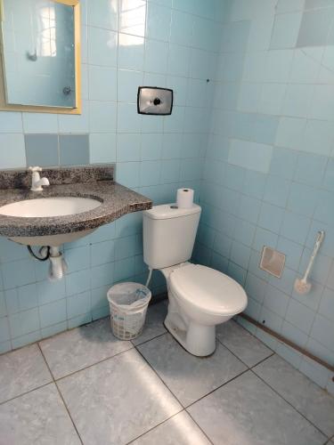 a bathroom with a white toilet and a sink at Casa das Hortas in São Luís