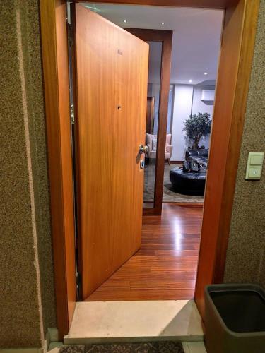 a wooden door leading into a room with a hallway at Luxury 3 Bedroom Penthouse With Private Garage in Braga