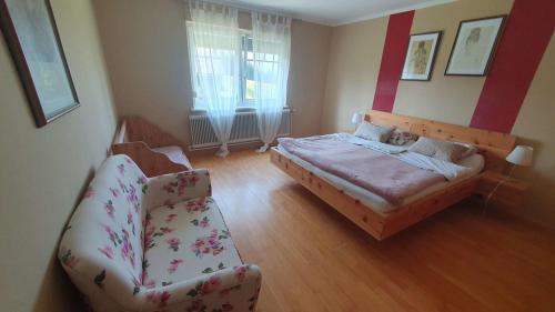 a bedroom with a bed and a couch and a chair at Ferienwohnung Wiener in Marchtring
