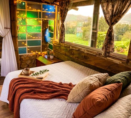 a bed in a room with a large window at Aldea Victoria EcoRefugio in Medellín