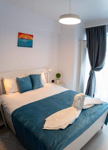 a bedroom with a large bed with a blue blanket at Eleven Odyssey Apartment in Năvodari