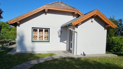 a small white building with a large window at Gartenidylle Melk in Melk