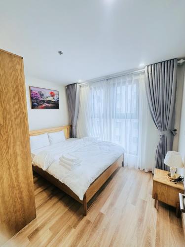 a bedroom with a bed and a large window at Rose Home in Lao Cai