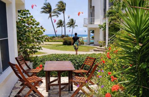 a table and chairs on a patio with a view of the ocean at Condo Cabrinha - Kite Beach Cabarete in Cabarete