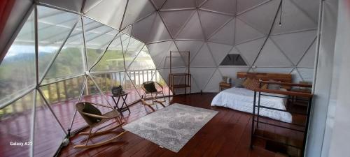 a room with a bed and a large glass wall at Cinco Elementos Glamping in Chiquinquirá
