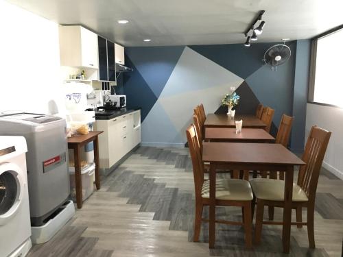 a kitchen with a table and chairs and a washing machine at The August Hostel in Chiang Mai