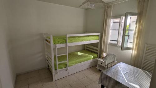 a small room with two bunk beds with a table at Gîte Barbera "Les Oliviers" in Grospierres