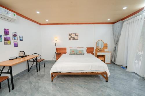 a bedroom with a bed and a desk and a desk at Dreamy Homestay in Xuân Sơn