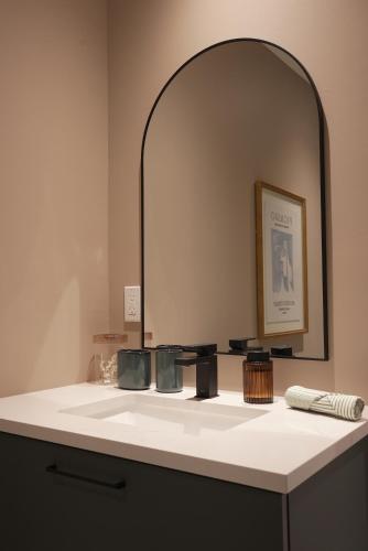 a bathroom with a sink with a large mirror at Studio 27 in Magog-Orford
