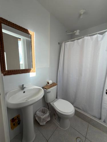 a bathroom with a sink and a toilet and a mirror at intikilla hostal in Ollantaytambo
