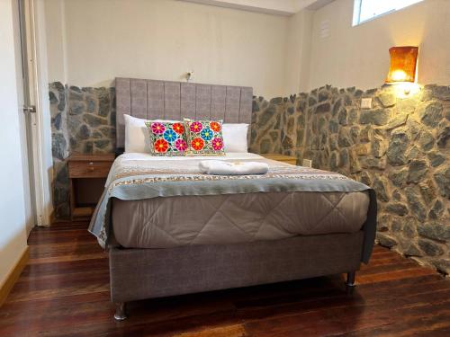a bedroom with a bed with pillows on it at intikilla hostal in Ollantaytambo