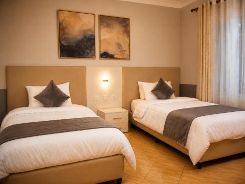a hotel room with two beds and a window at Cape Town K Hotel in Kigali