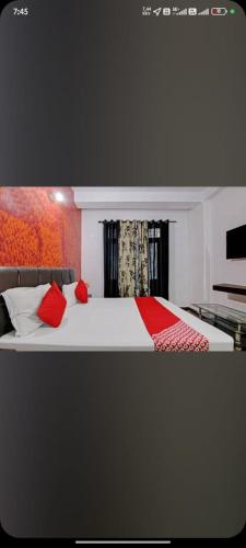 a bedroom with a large bed with red pillows at Hotel Manali Villa in Manāli