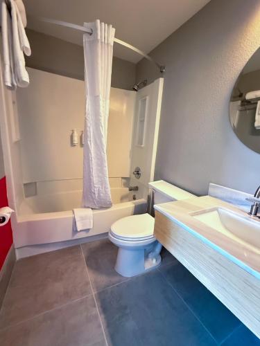 a bathroom with a toilet and a tub and a sink at Super 8 by Wyndham Windsor in Windsor