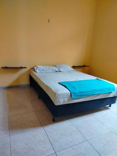 a bedroom with a bed with a blue blanket on it at Casa das Hortas in São Luís