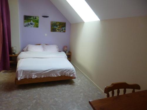 a bedroom with a bed with white sheets at Gîte des Oiseaux in Bieuzy-les Eaux