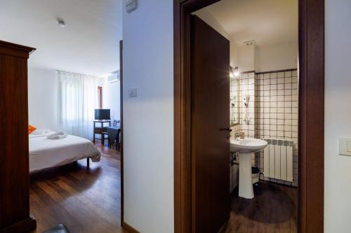 a bathroom with a bed and a sink in a room at Borgo Medievale in Castelmola