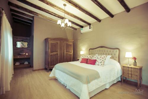 a bedroom with a white bed with red pillows at La Caballeriza Posada Boutique in San Rafael