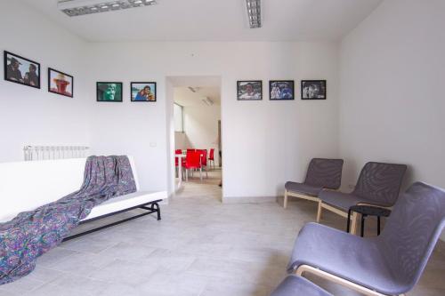 una sala de espera con sillas y cuadros en la pared en Ostello della Gioventù Massimo Troisi en Oliveto Citra