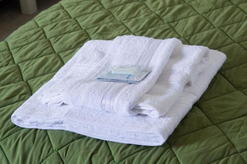 un mucchio di asciugamani seduti sopra un letto di Ostello della Gioventù Massimo Troisi a Oliveto Citra