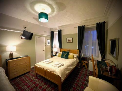 a bedroom with a bed and a dresser in it at Stag and Barrel in Elgin
