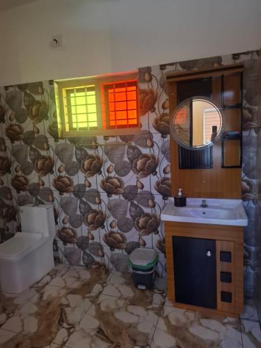a bathroom with a toilet and a sink and a mirror at Mountain Meadows Resort in Kollengode