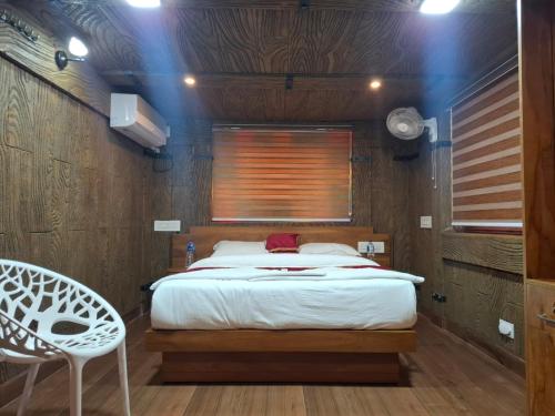 a bedroom with a bed and a wooden wall at Mountain Meadows Resort in Kollengode