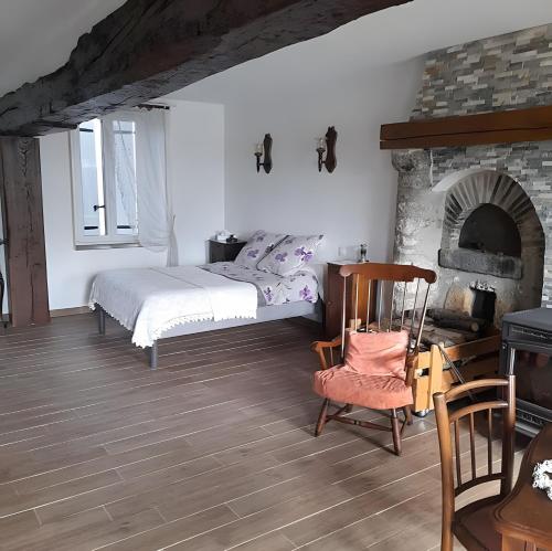a bedroom with a bed and a brick fireplace at Chambre d'hôtes Chez Sarah in Saint-Bon