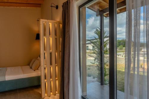 a bedroom with a bed and a large glass window at Maria village resort in Pavel Banya