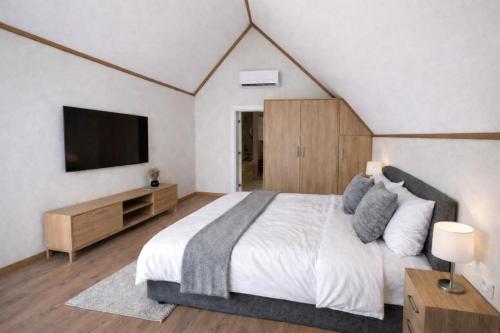 a bedroom with a large bed and a flat screen tv at Grand Piramit Kanyon Hotel in Pınarbaşı