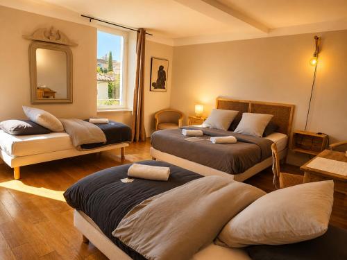 a bedroom with two beds and a window at Chambre d'hôtes Les Berges de l'Aude - B&B - Proche Canal du midi & Carcassonne in Puicheric