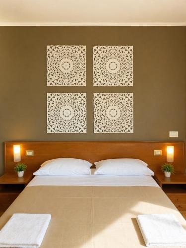 a bedroom with a large bed with two white pillows at Mariclà Boutique Rooms with Balcony & Free Parking in Verona