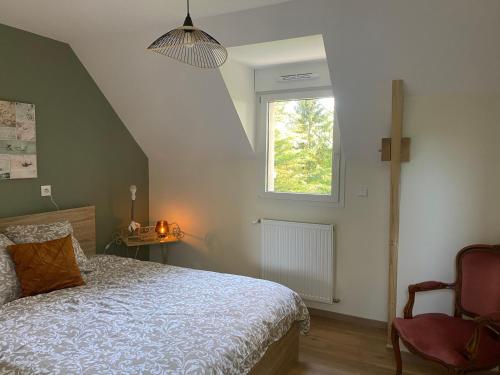 a bedroom with a bed and a window and a chair at Le Cocooning in Asnières