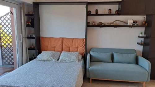 a bedroom with a bed and a couch and a chair at La terrazza sul Lago Maggiore in Brezzo