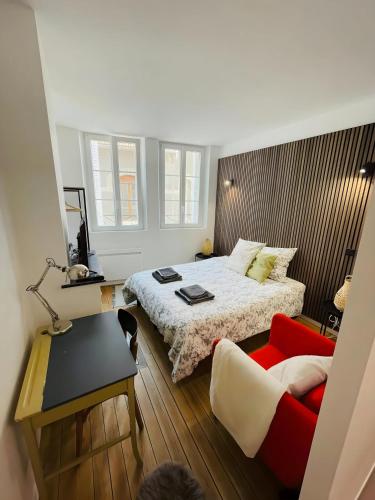 a small bedroom with a bed and a red chair at Le Charmant Bailla Science-Po in Reims