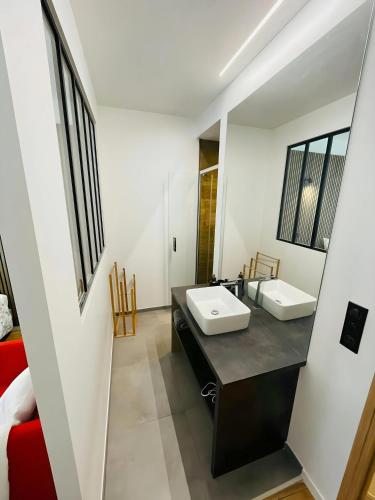 a bathroom with two sinks and a red couch at Le Charmant Bailla Science-Po in Reims