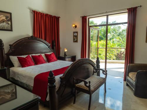 a bedroom with a bed with red pillows and a window at Villamorametro in Juan Dolio