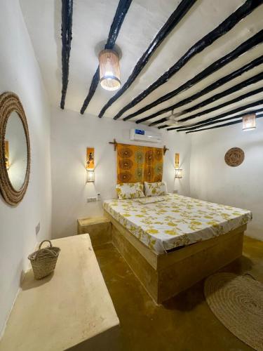 a bedroom with a bed and a table in a room at Beach House in Jambiani