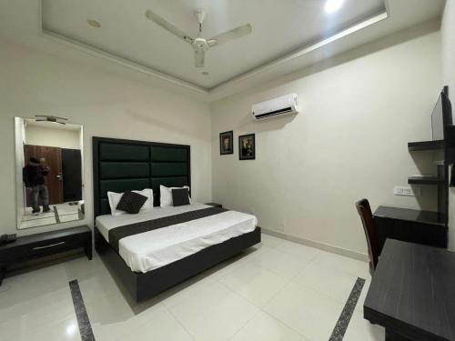 a bedroom with a large bed and a mirror at Hotel Oval Hut in Jalandhar