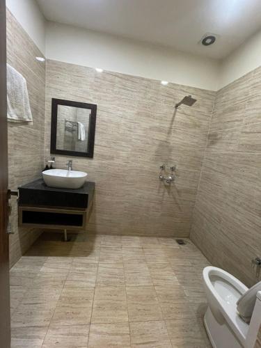 a bathroom with a sink and a toilet at Hotel Oval Hut in Jalandhar