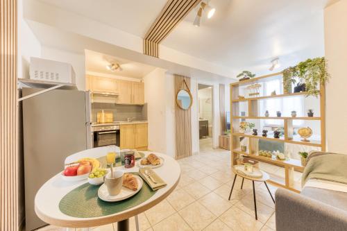 a kitchen and living room with a table with food on it at Évasion à deux, studio neuf et design à Tarbes, gare à 700 m, arrivée autonome in Tarbes