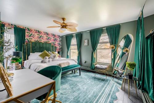 a bedroom with green walls and a bed and a fan at 2 Fun Homes in Hudson