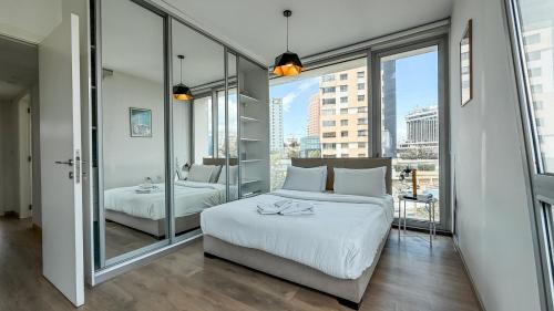 a bedroom with two beds and a large window at The Cube 10, 3-BR in Sin El Fil in Beirut