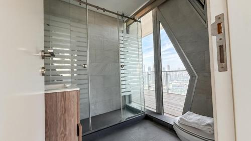 a bathroom with a shower and a toilet and a window at The Cube 10, 3-BR in Sin El Fil in Beirut