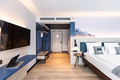 a bedroom with a large bed and a tv at Holiday Inn - the niu, Quay Hamburg Harburg by IHG in Hamburg