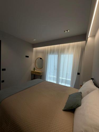 a bedroom with a large bed with a large window at Elea Living Chios in Chios