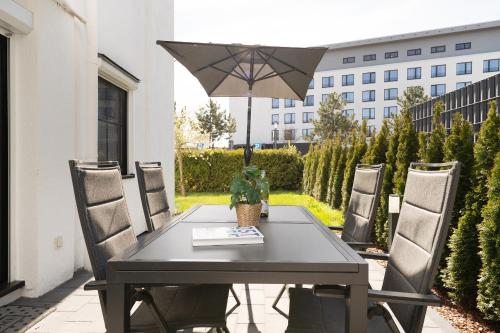 a black table and chairs with an umbrella at Haus Titania Wohnung 2 in Grömitz